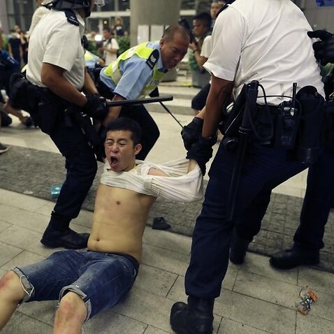 Hong Kong police officers drag away a protester