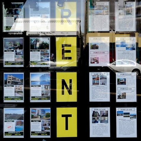 Houses for sale and lease are advertised in the window of a real estate agent at Bondi in Sydney.