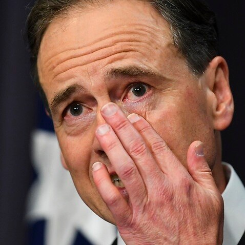 Health Minister Greg Hunt wipes away a tear during a press conference at Parliament House in Canberra