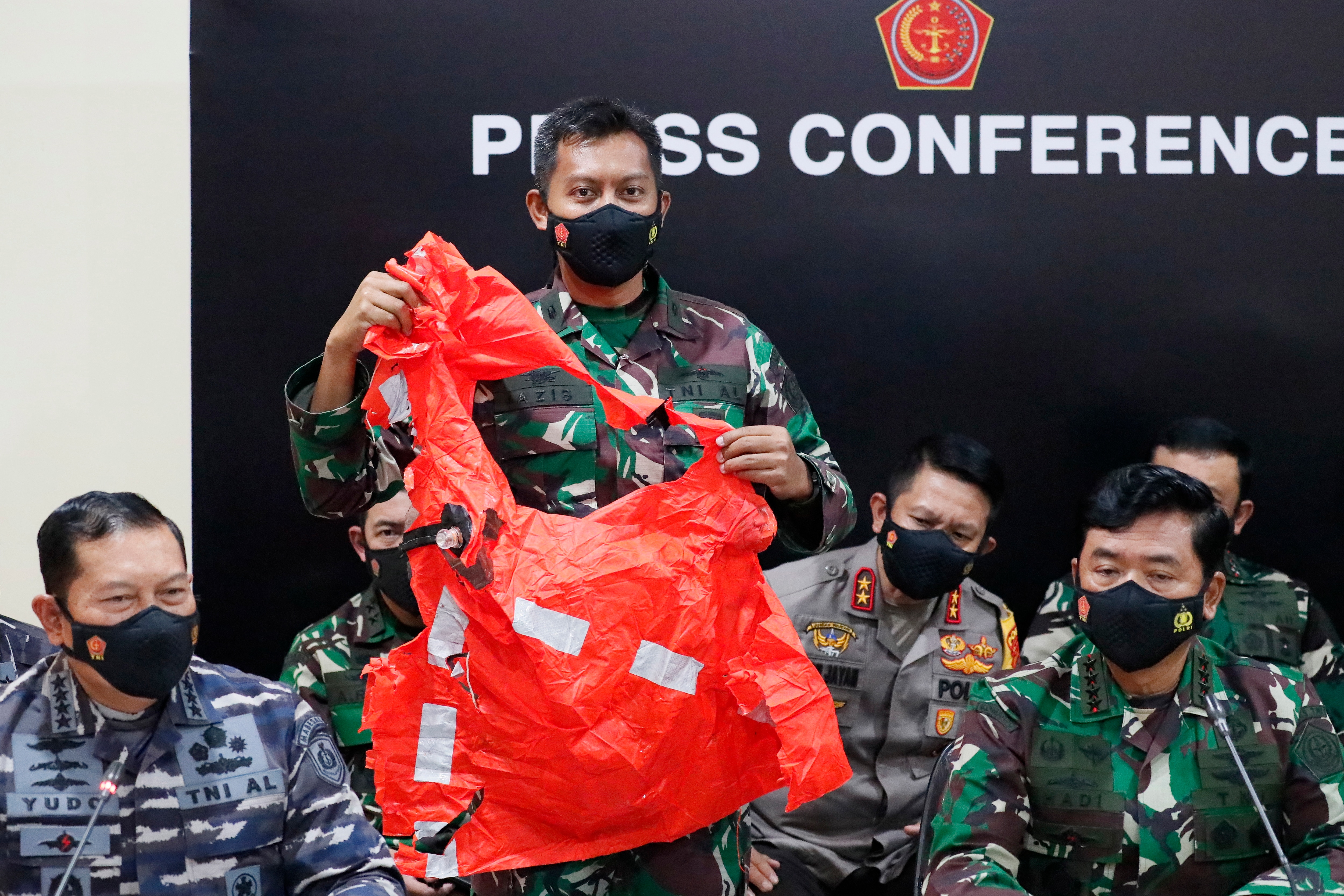 A military officer shows a safety escape suit believed to be from the Indonesian submarine during a press conference in Bali, Indonesia, on 25 April.