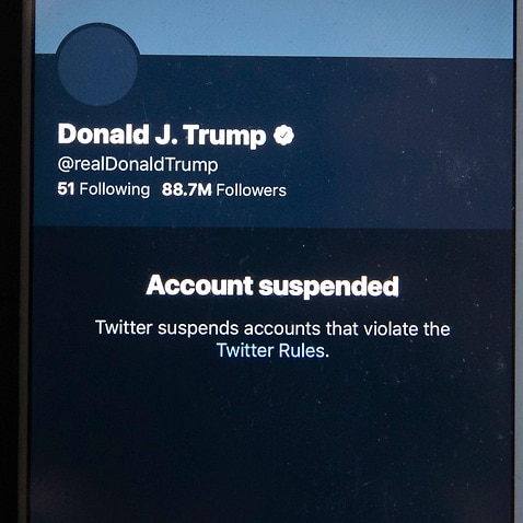 A mobile phone displays the suspended status of the Twitter account of US President Donald Trump.
