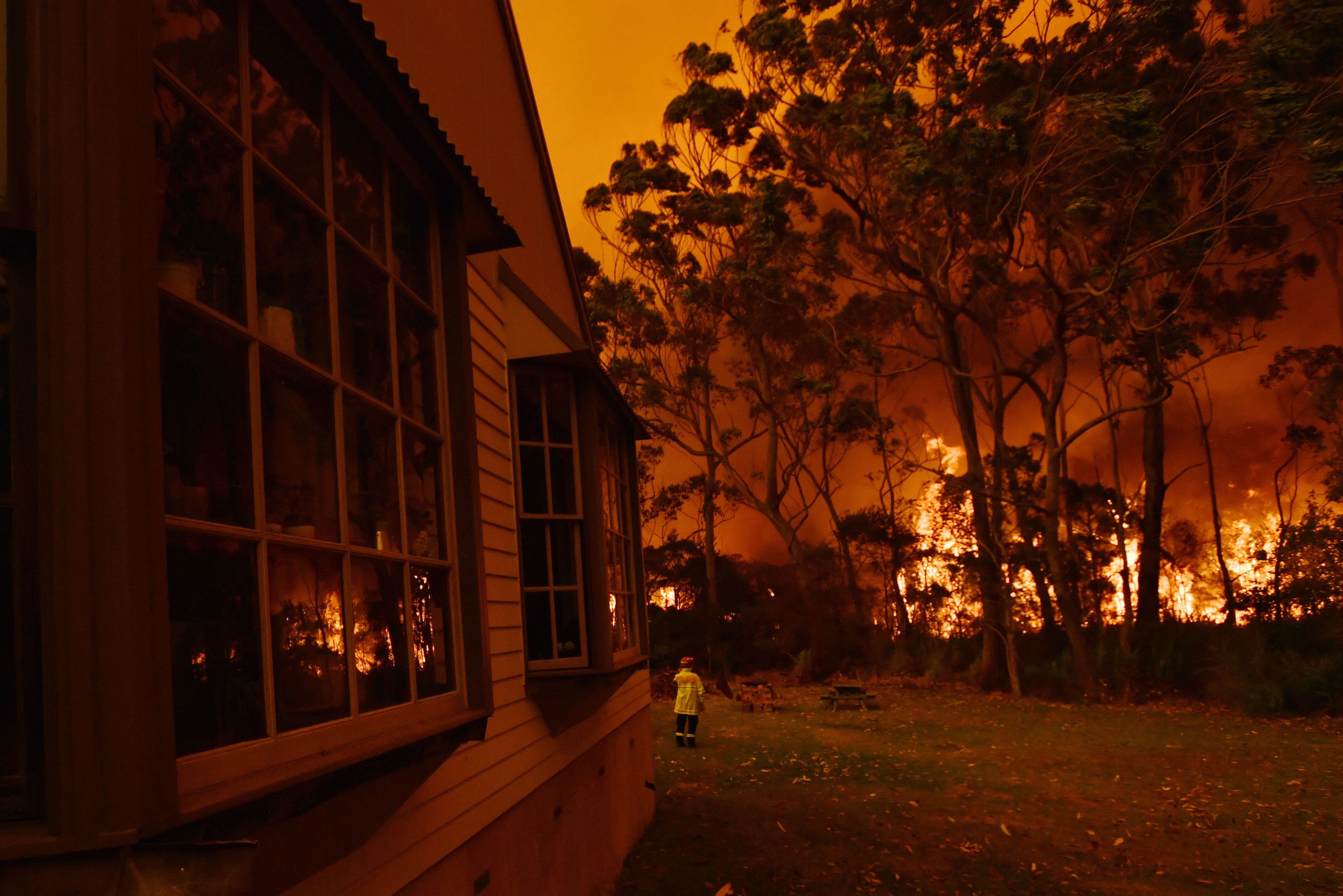 تحارب طواقم مكافحة الحرائق حريق غابات على ممتلكات بالقرب من بحيرة تابوري على الساحل الجنوبي لنيو ساوث ويلز.