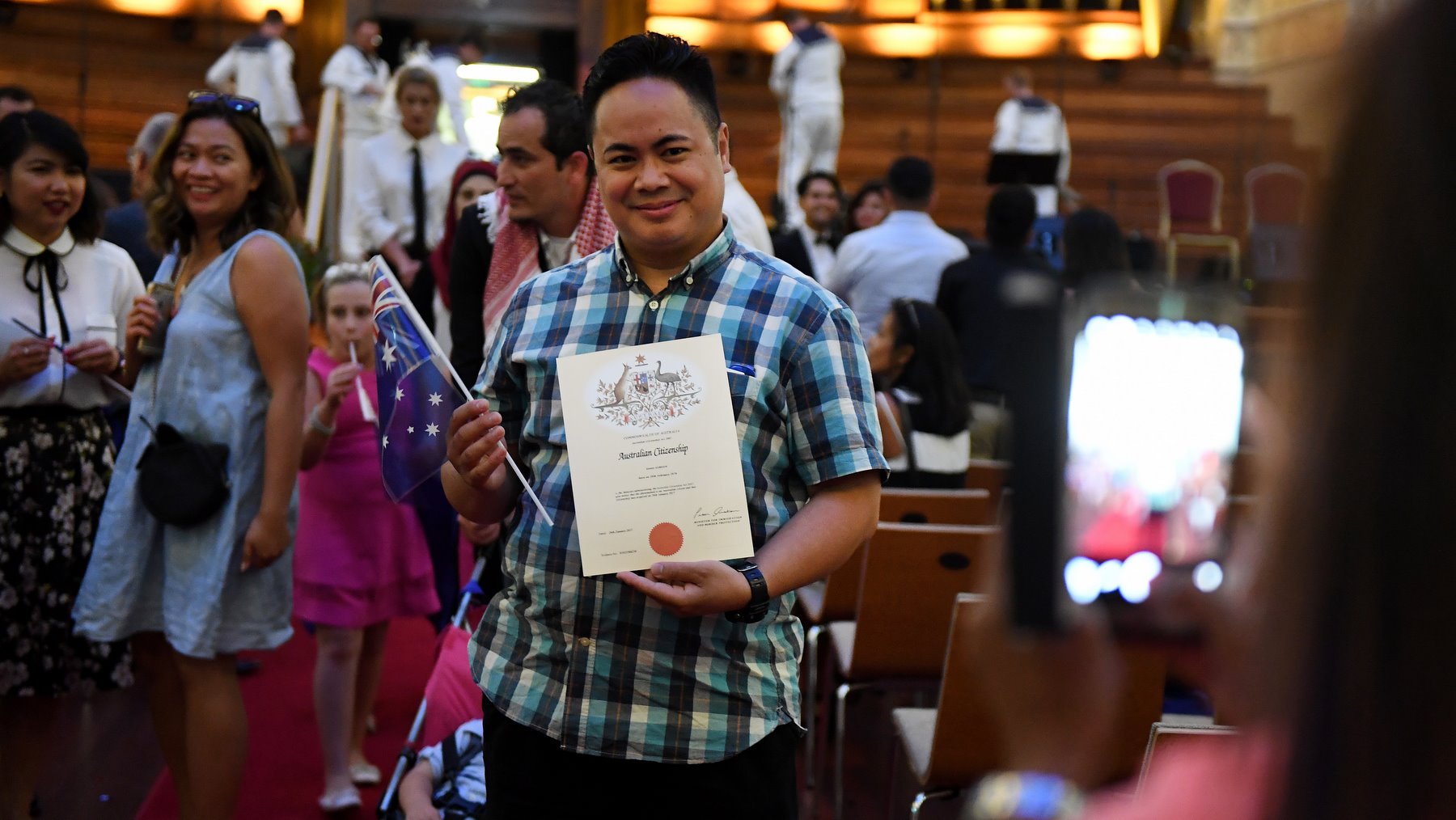 An Australian citizenship recipient poses for a photo after  a citizenship ceremony on Australia Day in Brisbane, Thursday, Jan. 26, 2017. (AAP Image/Dan Peled) 