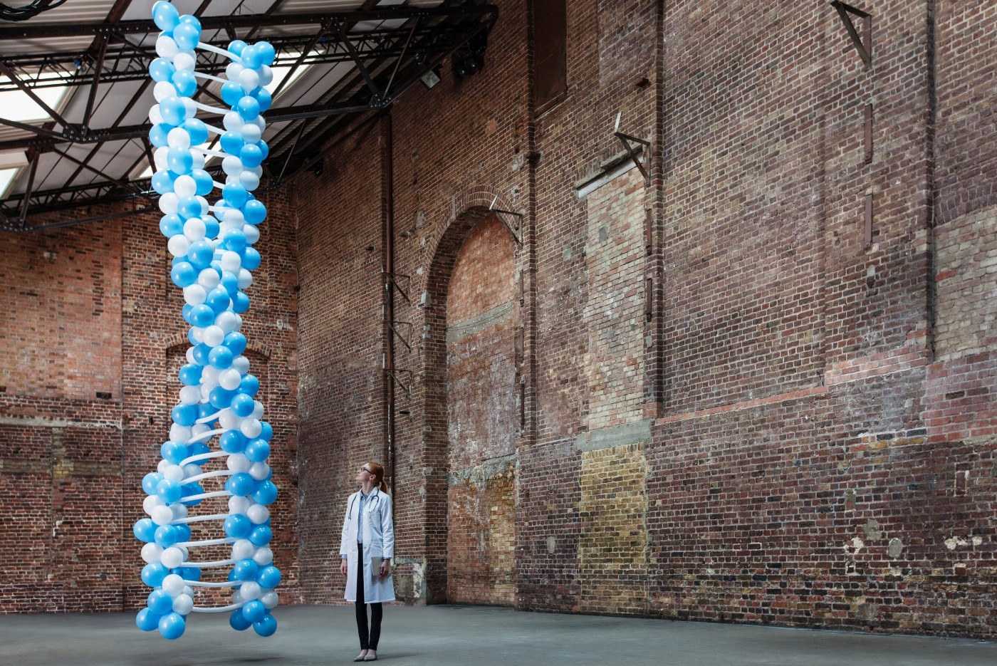 Doctor in warehouse with DNA made of balloons