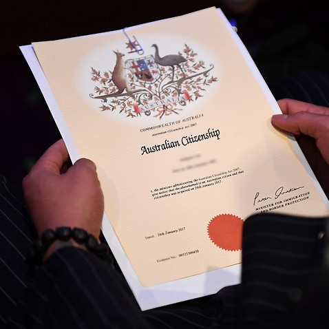An Australian citizenship recipient holds his certificate during a citizenship ceremony on Australia Day in Brisbane, Thursday, Jan. 26, 2017. (AAP Image/Dan Peled) NO ARCHIVING