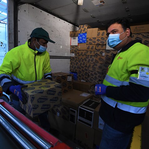 Employees load parcels into a delivery truck at Australia Post’s Sunshine West Parcel Delivery Centre in Melbourne, 16 November 2021.