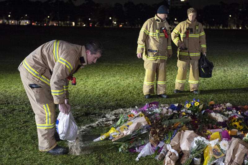 Firefighters clean graffiti painted at the memorial site of murdered Melbourne comedian Eurydice Dixon at Princess Park in Melbourne