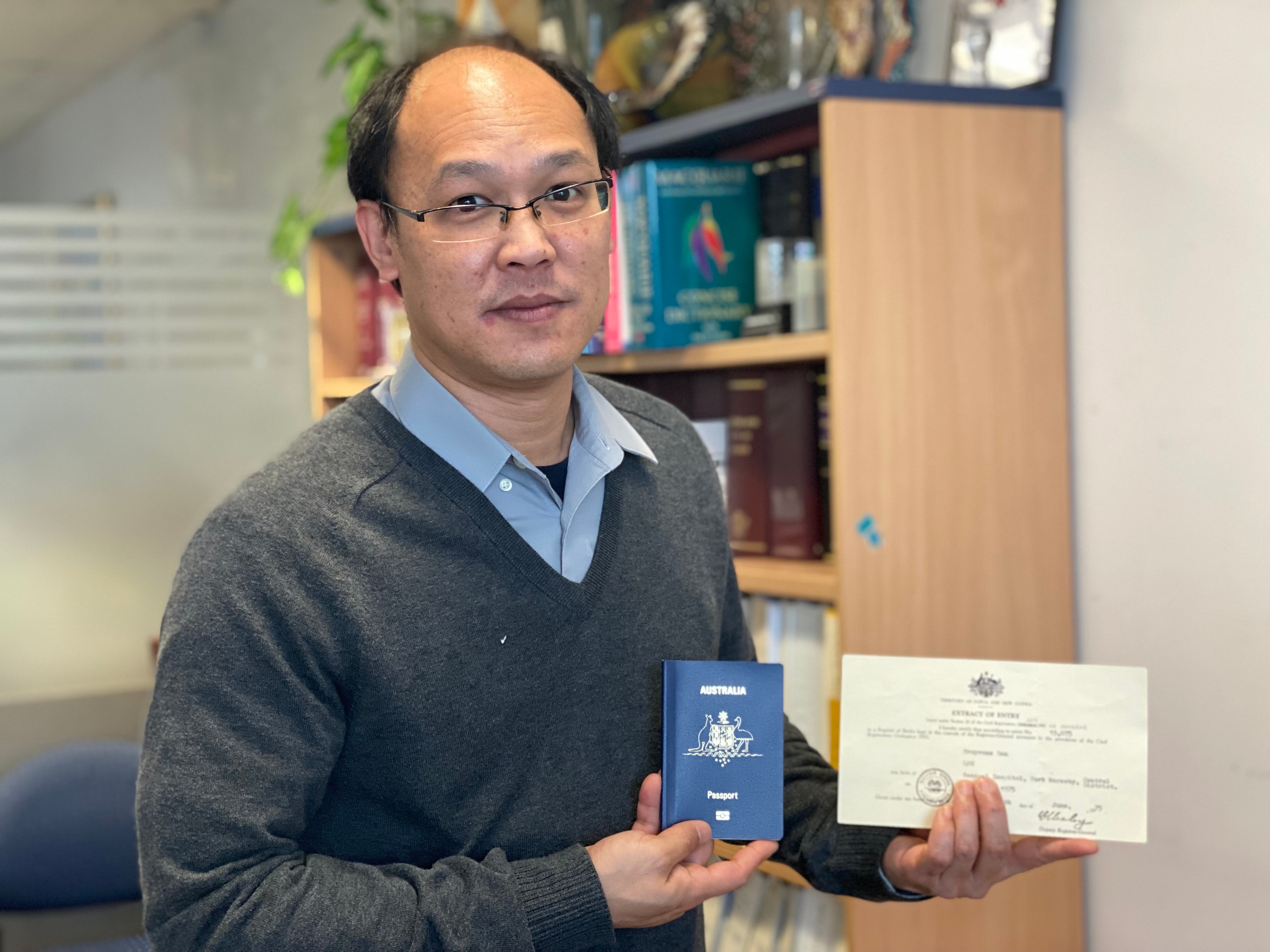 Troy Lee with his new Australian passport and certificate registering his birth.