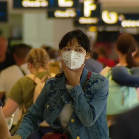 Travellers wear masks at Sydney Airport.