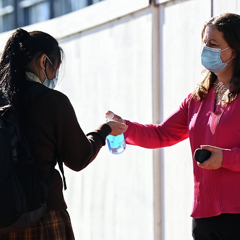 A student applies hand sanitiser in NSW