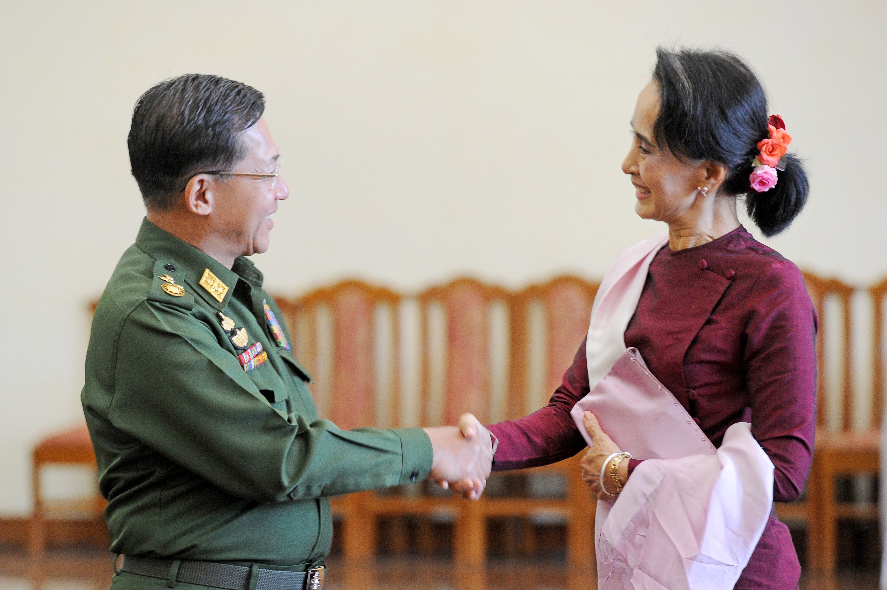 Senior General Min Aung Hlaing and National League for Democracy (NLD) party leader Aung San Suu Kyi (R) shake hands after a meeting in December 2015. 