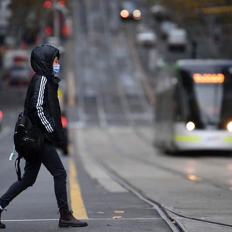A person is seen wearing a face mask in Melbourne, Friday, June 4, 2021. Victoria has recorded four new locally acquired cases of coronavirus in the past 24 hours. (AAP Image/James Ross) NO ARCHIVING