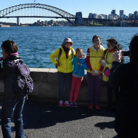  Chinese tourists take in the sites of the Sydney Harbour Bridge and the Sydney Opera House from Mrs Macquarie's Chair in Sydney, Tuesday, July 14, 2015. (AAP Image/Dean Lewins) NO ARCHIVING (AAP) 