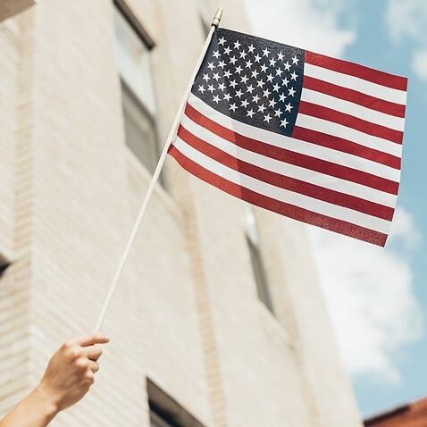 Waving American Flag Across City