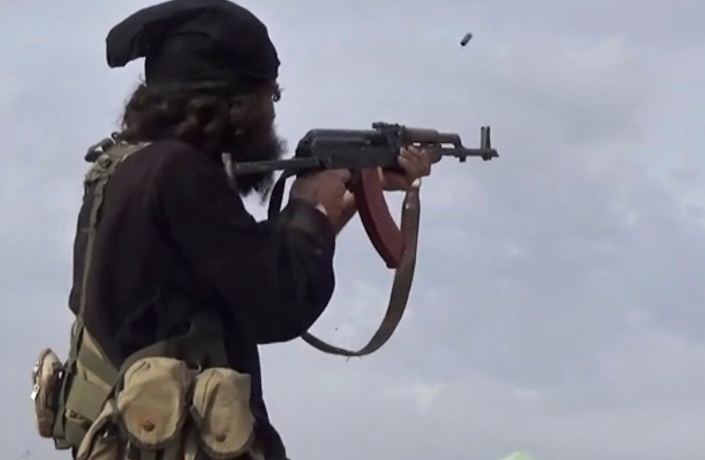 File frame grab from video posted on Monday, March 18, 2019, by the Aamaq News Agency, shows an IS fighter firing his weapon.