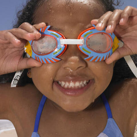 Smiling girl wearing goggles at beach