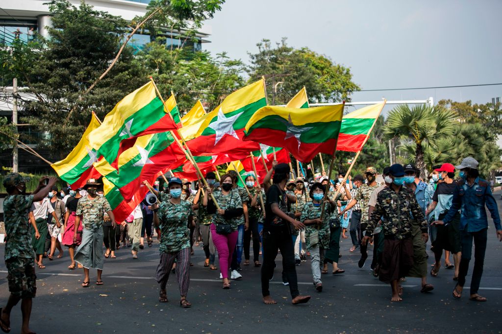 Military supporters carry Myanmar's national flags during a protest to demand an inquiry to investigate the Union Election Commission (UEC) in Yangon on 30 January 2021.