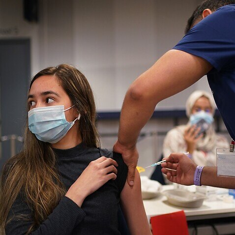 a woman receiving a Pfizer BioNTech COVID-19 vaccine at an NHS Vaccination Clinic at Tottenham Hotspur's stadium in north London. 