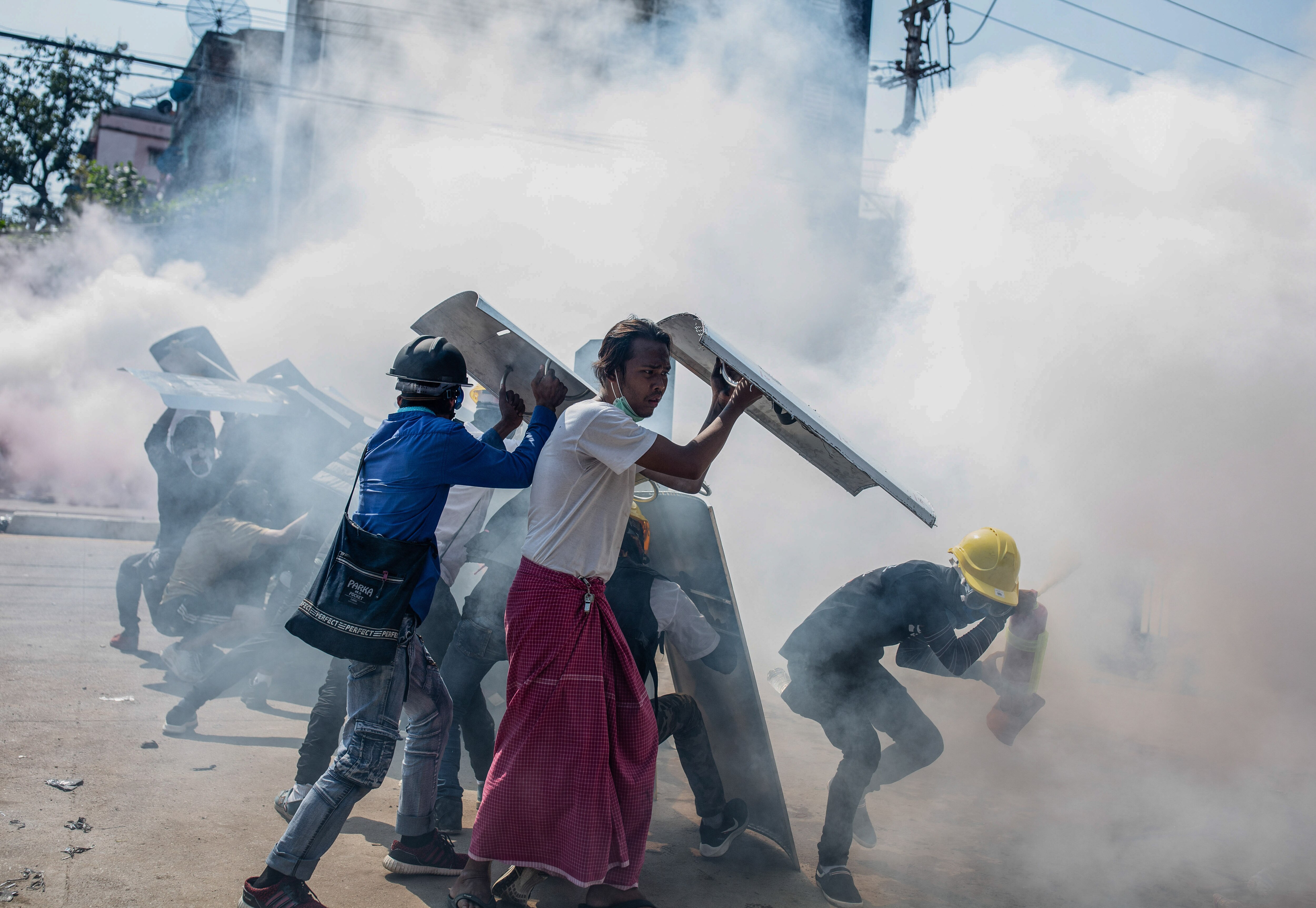 Protesters react after riot police fire tear gas in Myanmar.
