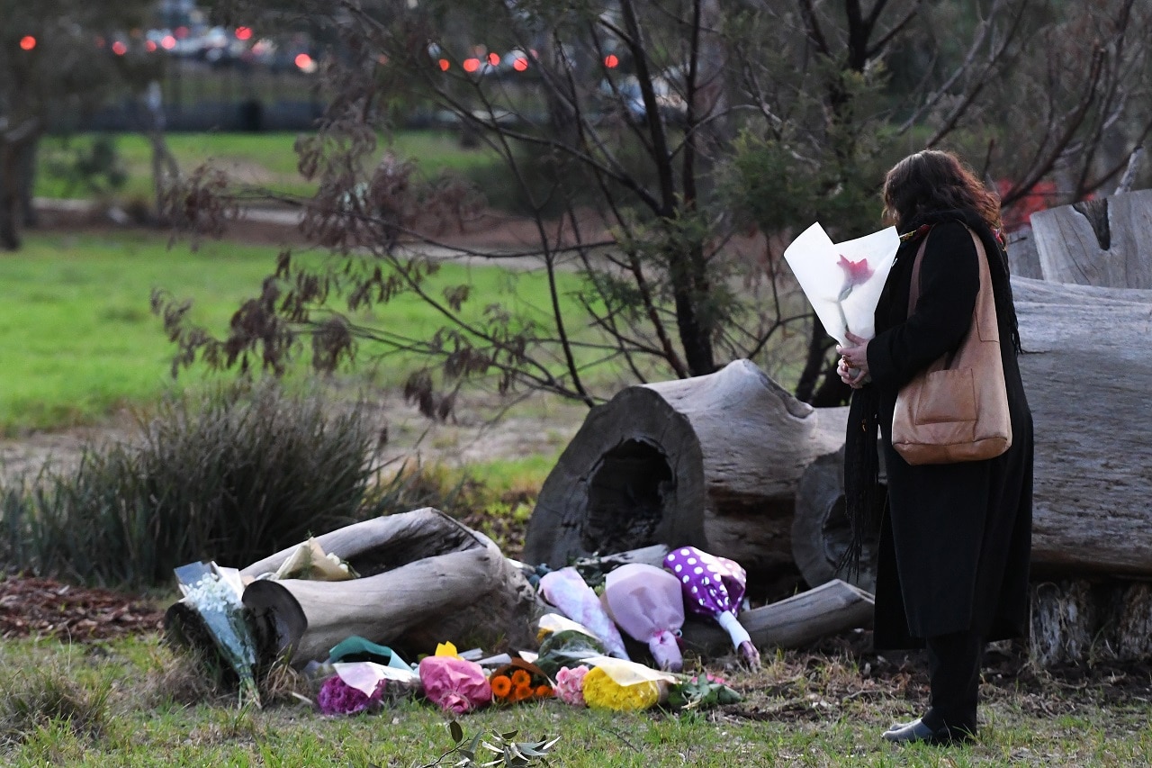 A mourner is seen laying flowers for Courtney Herron.