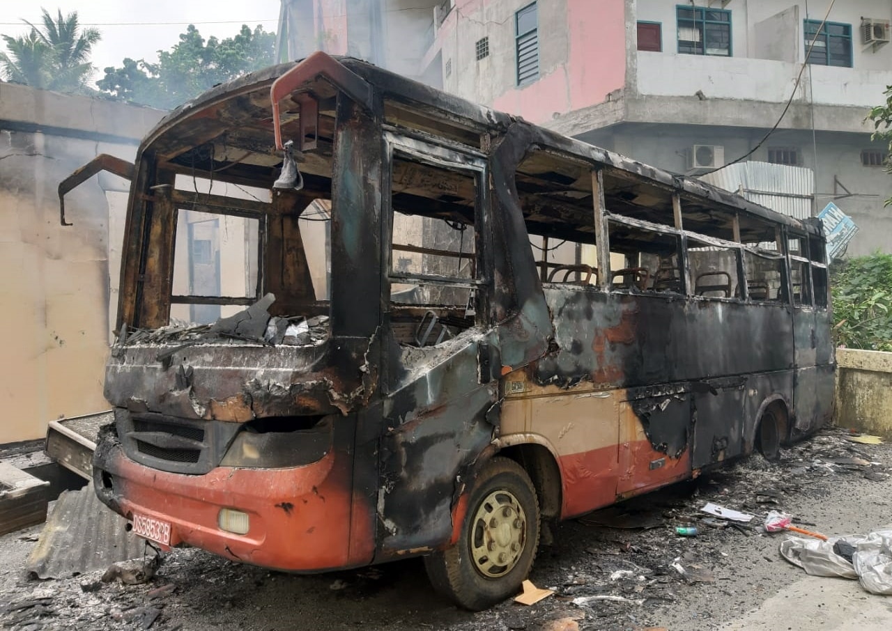 A burnt bus sits outside the parliament building during a protest earlier this month.