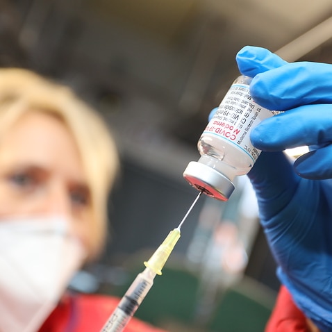 A nurse prepares a COVID-19 vaccine. 