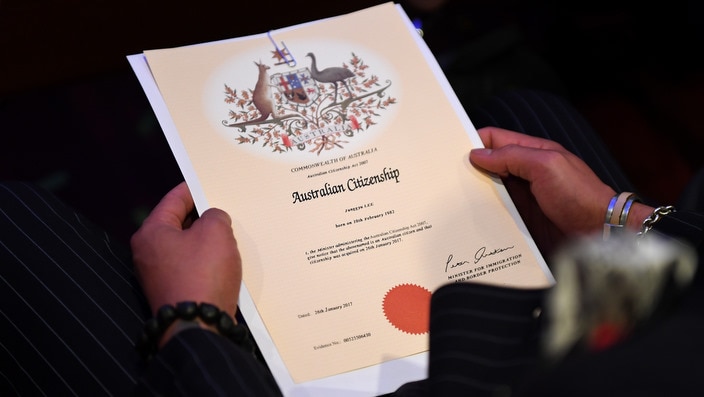 An Australian citizenship recipient holds his certificate during a citizenship ceremony on Australia Day in Brisbane, Thursday, Jan. 26, 2017. (AAP Image/Dan Peled) NO ARCHIVING