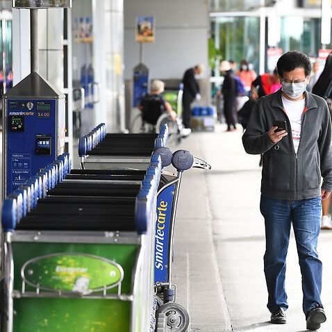 A man with a face mask is seen outside the international departures terminal at Tullamarine Airport, Melbourne, Friday, March 13, 2020. 