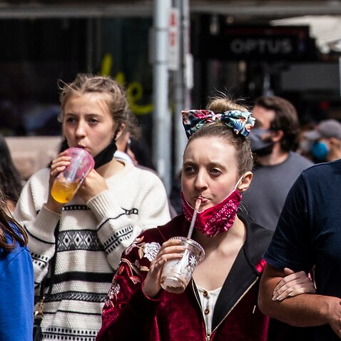 People wearing face masks are seen walking on Elizabeth Street, Melbourne, 7 November 2020.