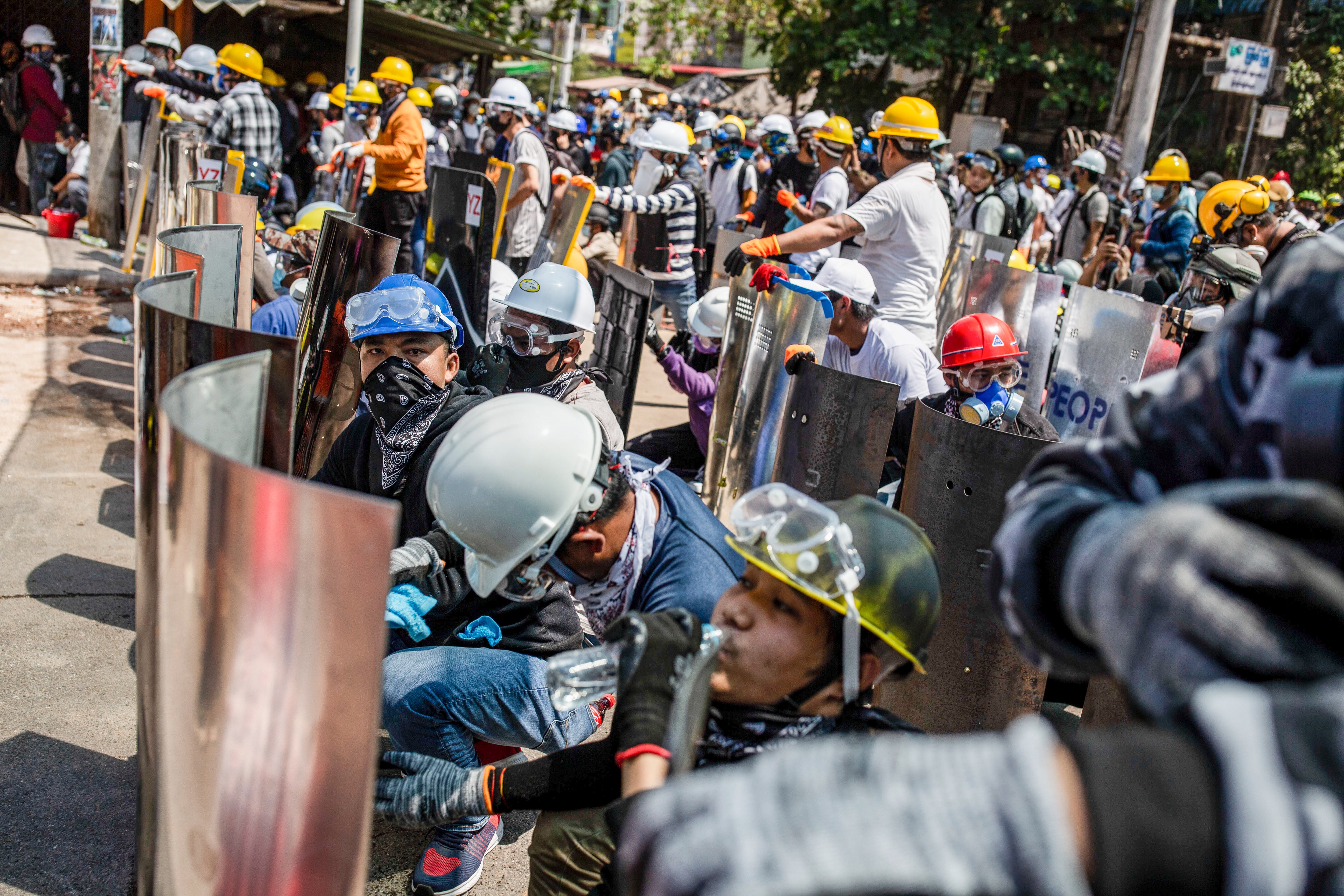 Protesters gather behind makeshift shields during a demonstration against the military coup in Myanmar.
