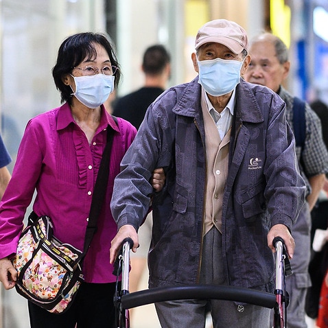 A couple wearing face masks in Sydney (AAP)