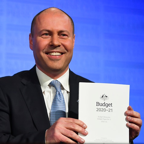 Treasurer Josh Frydenberg holds the Budget papers ahead of delivering an address to the National Press Club.