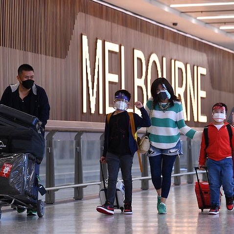 Passengers who travelled on Flight SQ237 from Singapore are seen exiting the international arrivals terminal at Tullamarine Airport in Melbourne.