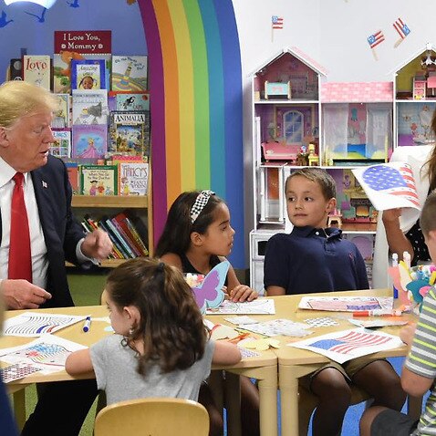  President Trump using a blue marker to colour the flag.