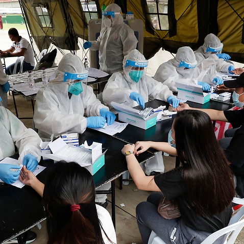 Health workers wear protective suits as they perform COVID19 rapid tests to Filipinos.