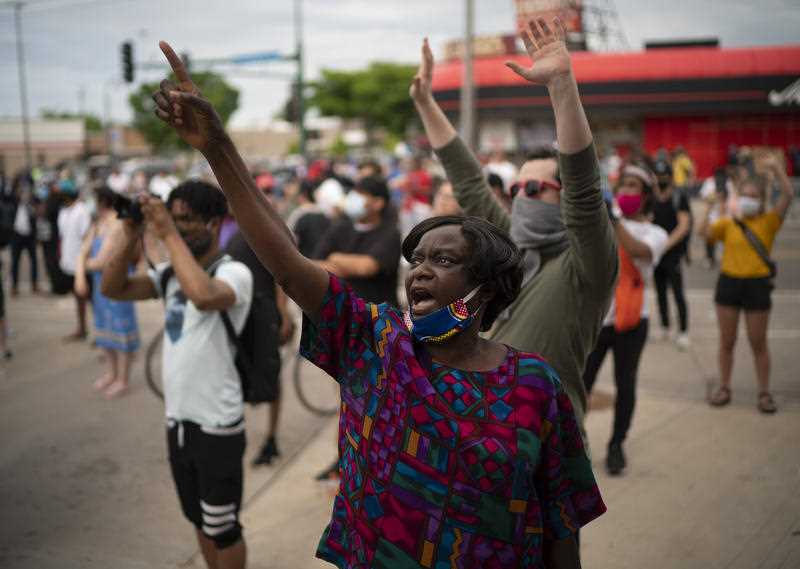 Demonstrators chant at police officers outside the Minneapolis Police Department's Third Precinct office on Wednesday, May 27, 2020
