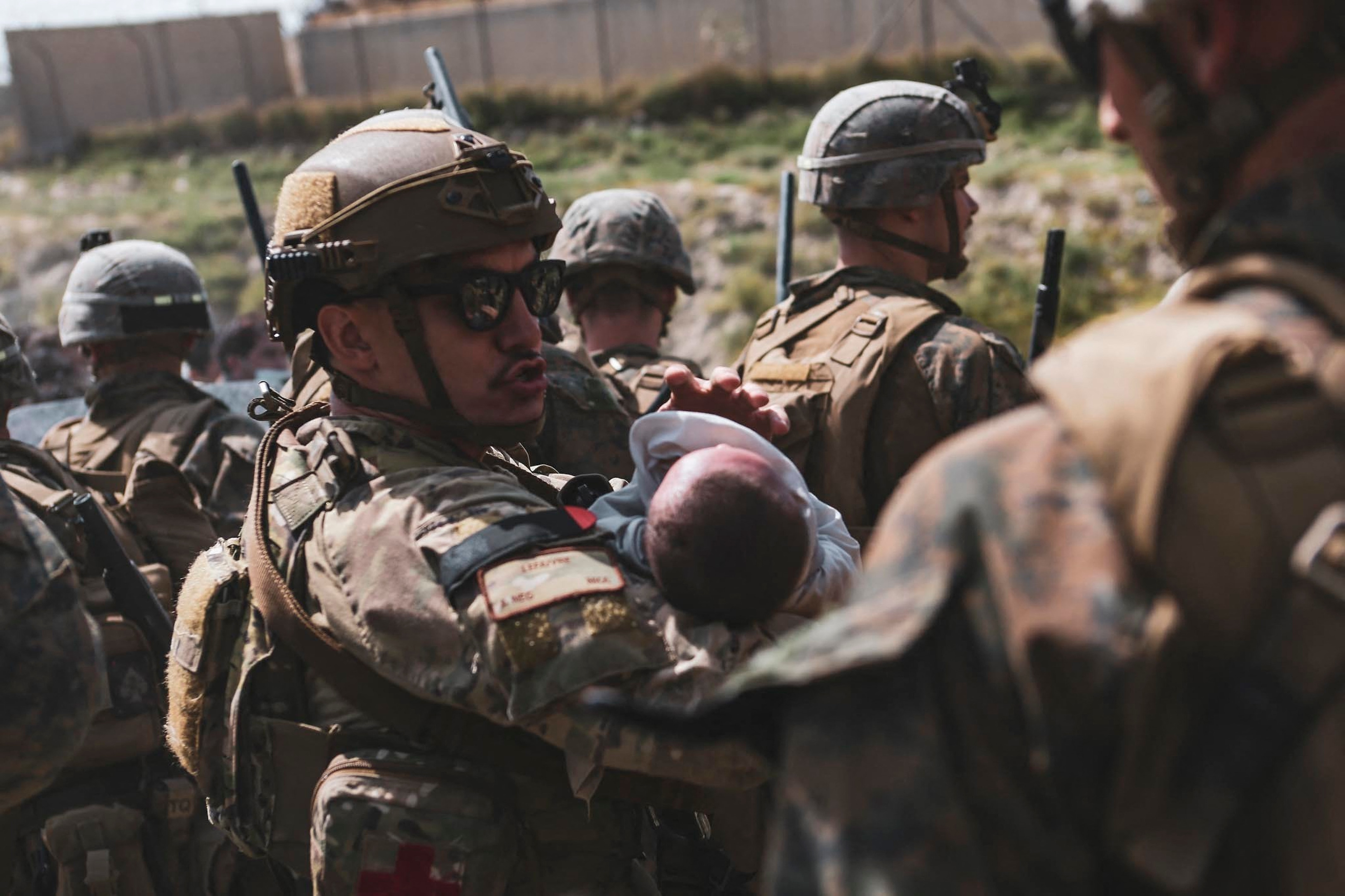 A US soldier calms an infant during an evacuation at Hamid Karzai International Airport, Kabul, Afghanistan.