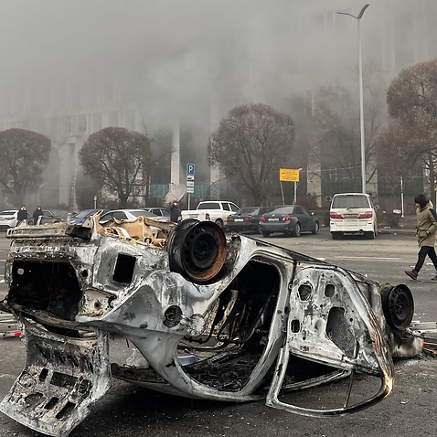 A burnt out vehicle which was set on fire during unrest is seen in Almaty's Republic Square. 