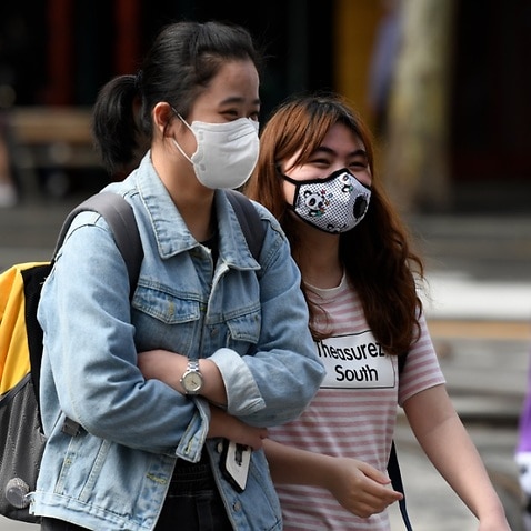 People are seen wearing face masks in Sydney, Monday, March 9, 2020.