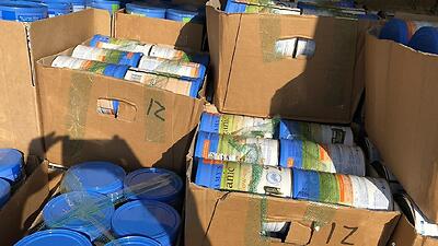 Thousands of baby formula tins seized by police.