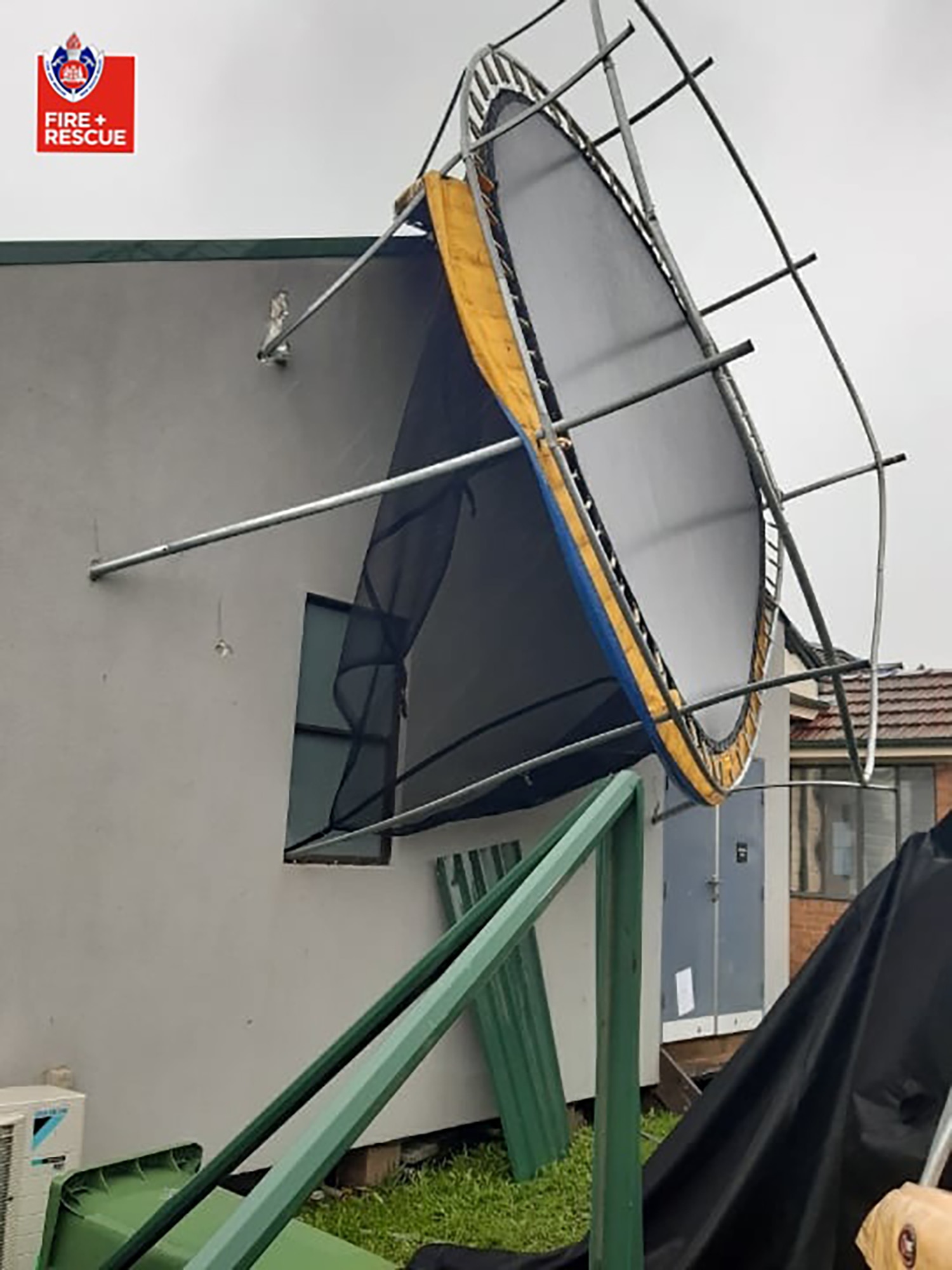 A supplied image obtained on Saturday, 20 March, shows a trampoline stuck against the side of a house in Chester Hill, Sydney. 