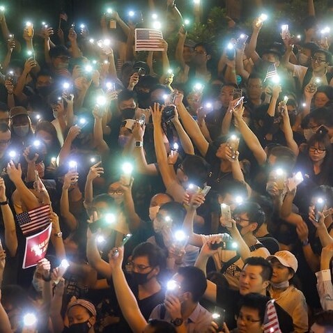 Protesters hold up the flashlights of their mobile phones at a rally at Chater Garden in the the Central district in Hong Kong, China, 14 October 2019.