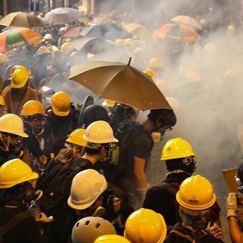 Anti-extradition bill protesters stand surrounded by tear gas smoke fired by riot police during a rally against the police brutality in Hong Kong, China.