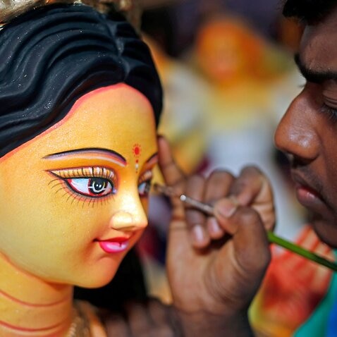 A Bangladeshi artist gives the final touches to an idol of the Goddess Durga ahead of the largest Durga Puja festival of the Bengali Hindus community in Dhaka.