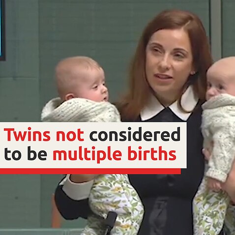 MP gives speech holding baby twins for Multiple Birth Awareness week.
