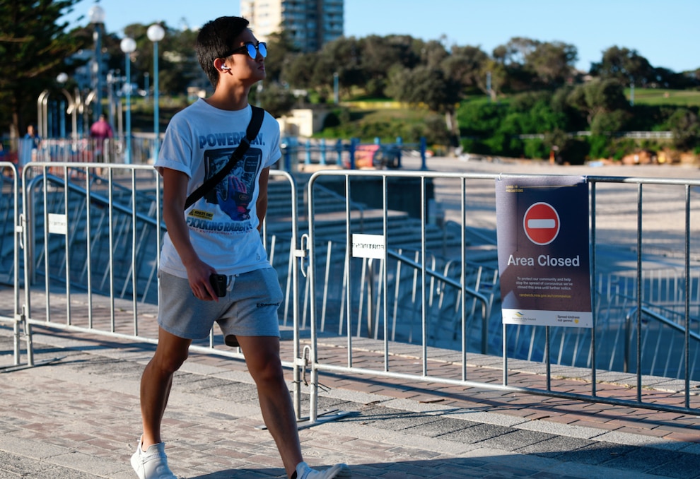 A beachgoers walks past a closed entry point to Coogee Beach in Sydney.