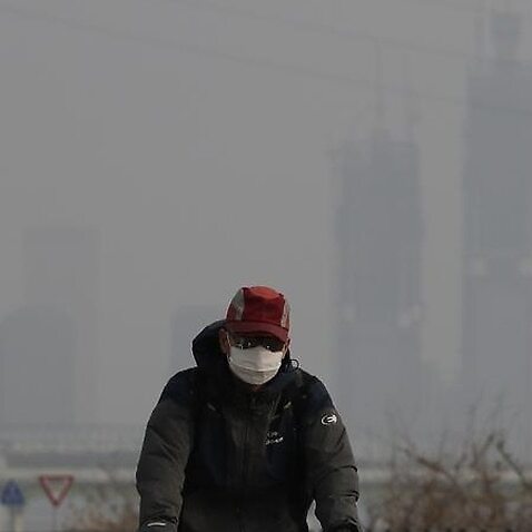 Image of a cyclist wearing a mask amongst polluted air.