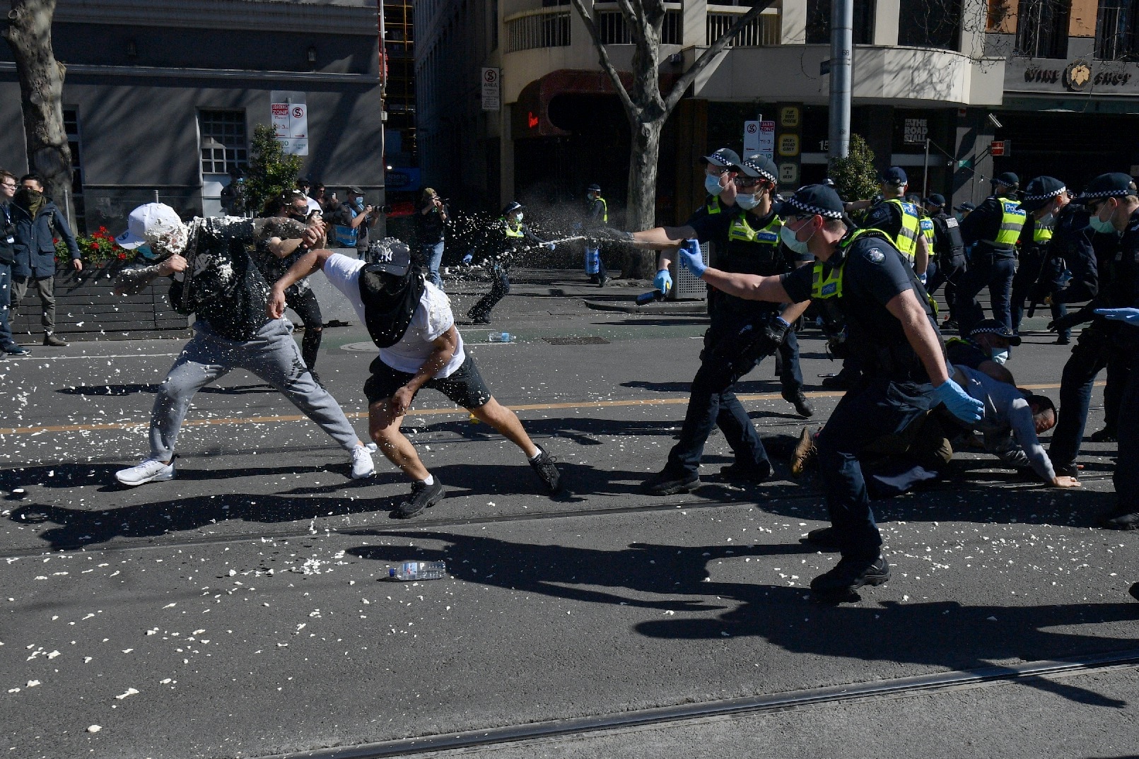 Les manifestants sont aspergés de poivre par la police lors d'une manifestation anti-verrouillage dans le quartier central des affaires de Melbourne.