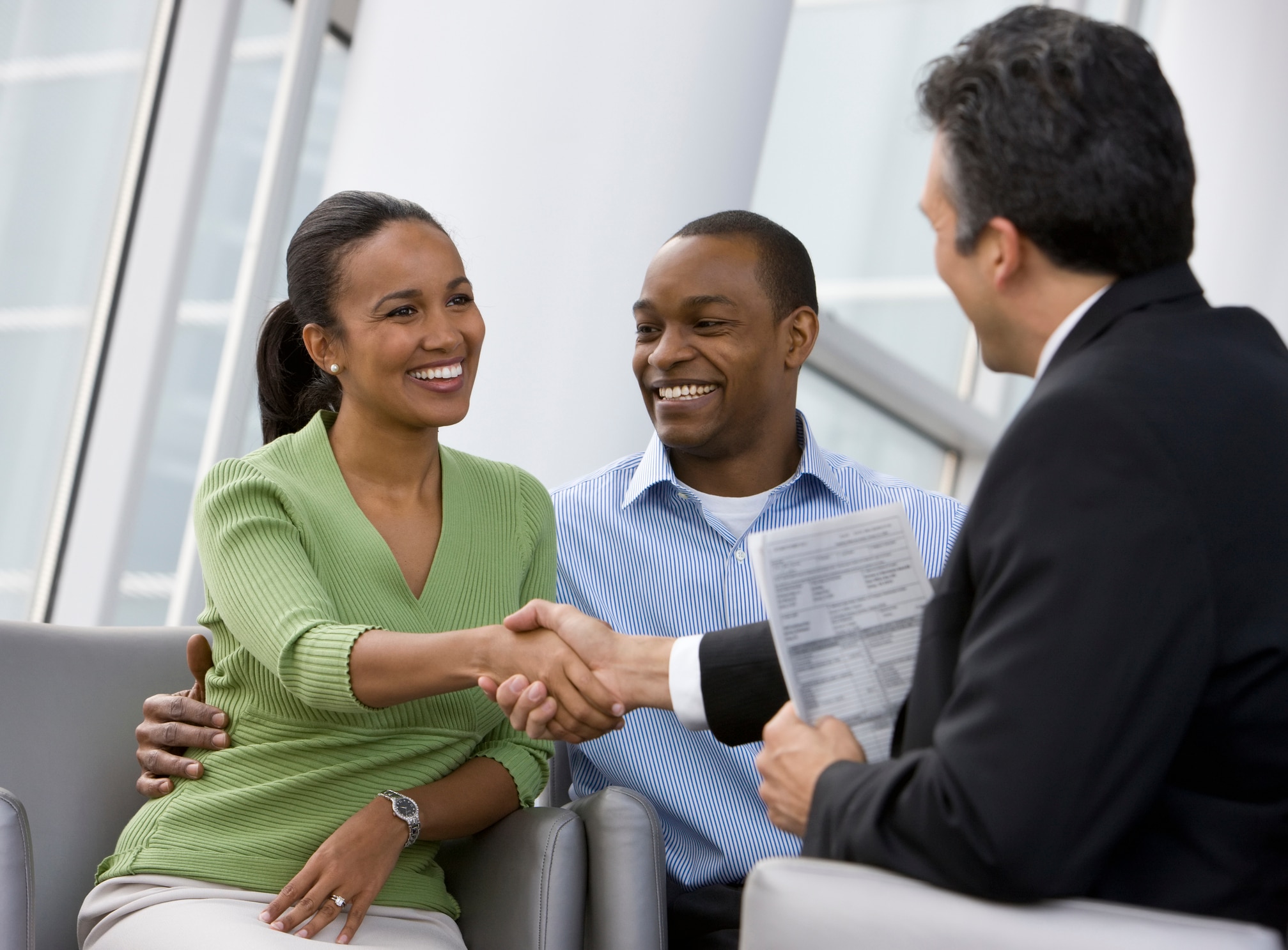 African couple shaking hands with financial advisor