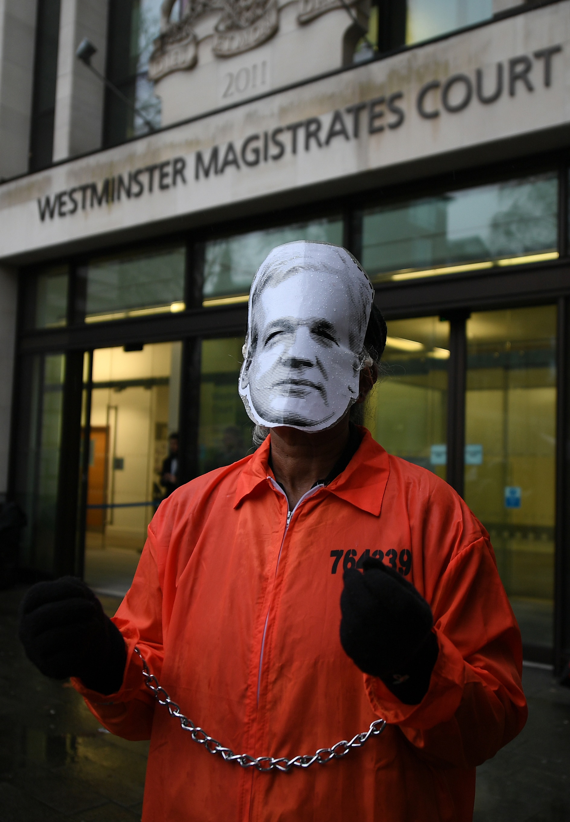 Supporters of WikiLeaks founder Julian Assange hold placards as they demonstrate outside the entrance to Westminster Magistrates Court.